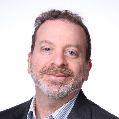 Jeremy Warner wearing a suit jacked and button down shirt